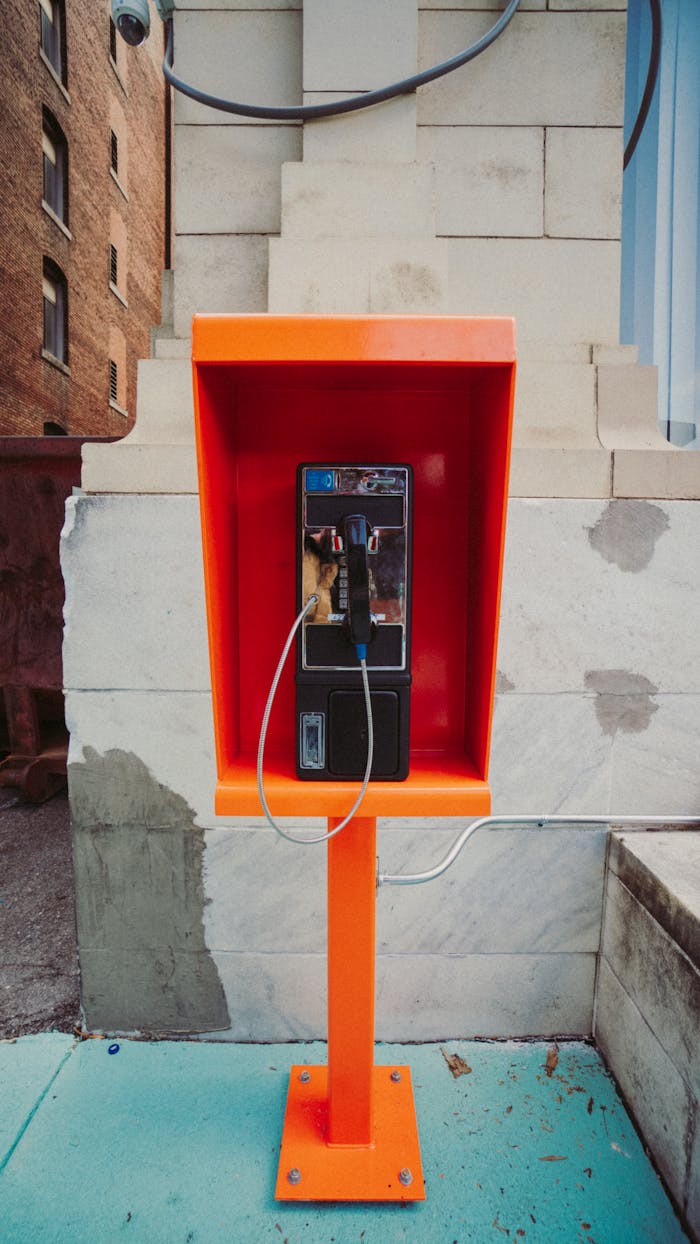 Payphone near shabby wall on street